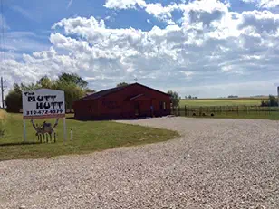 Brown commercial building with a roadside sign in open country