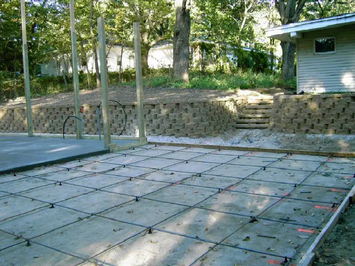 Curved block retaining wall and steps behind a new patio pad