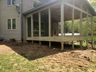Screened porch under construction off the back of a two-story home