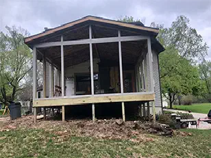Covered screened porch on posts behind a house
