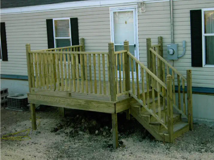 New wood deck and railing around the back of a house