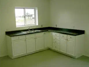 Kitchen with white cabinets and dark counters