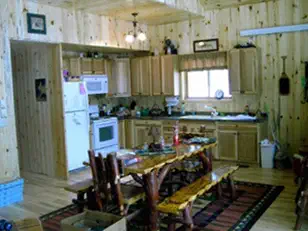 Cabin kitchen and dining room with knotty pine walls