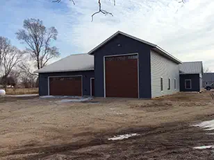 Tall shop wing with an oversized door on a new home