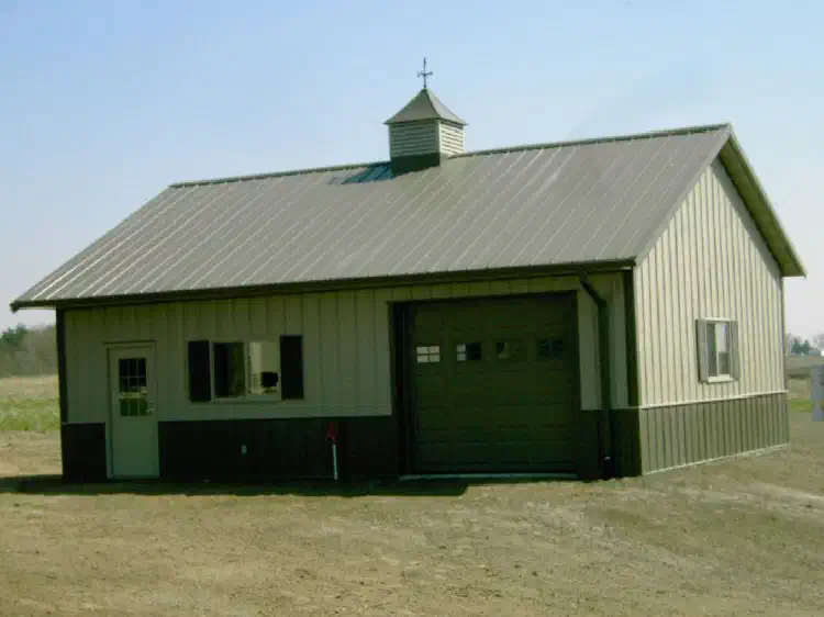 Green and white garage with a cupola