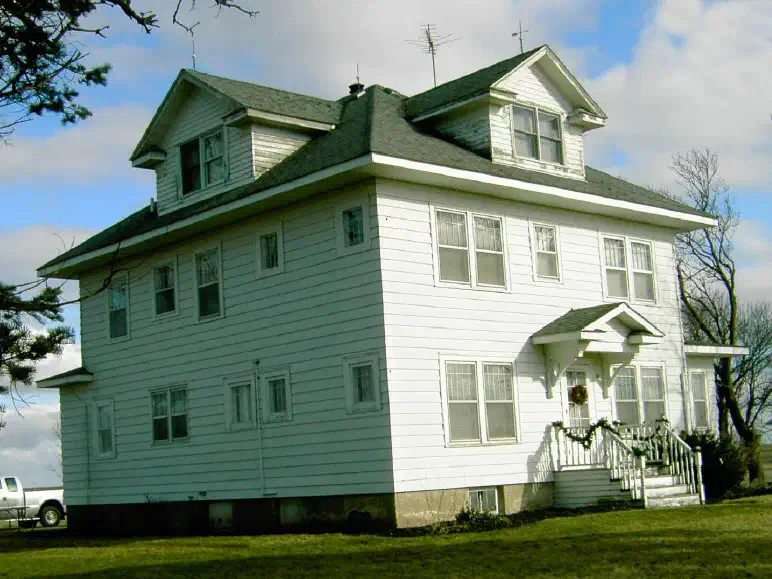 Two-story white farmhouse with a dark shingle roof