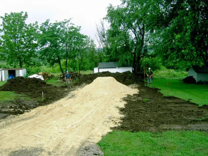 Fresh rock driveway cut across a lawn to a new building site