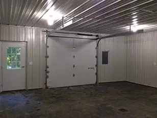 Insulated overhead door and service door inside a finished steel shop