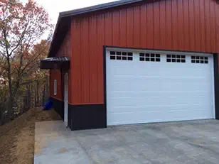 Side of a red and black garage with a window-lite door